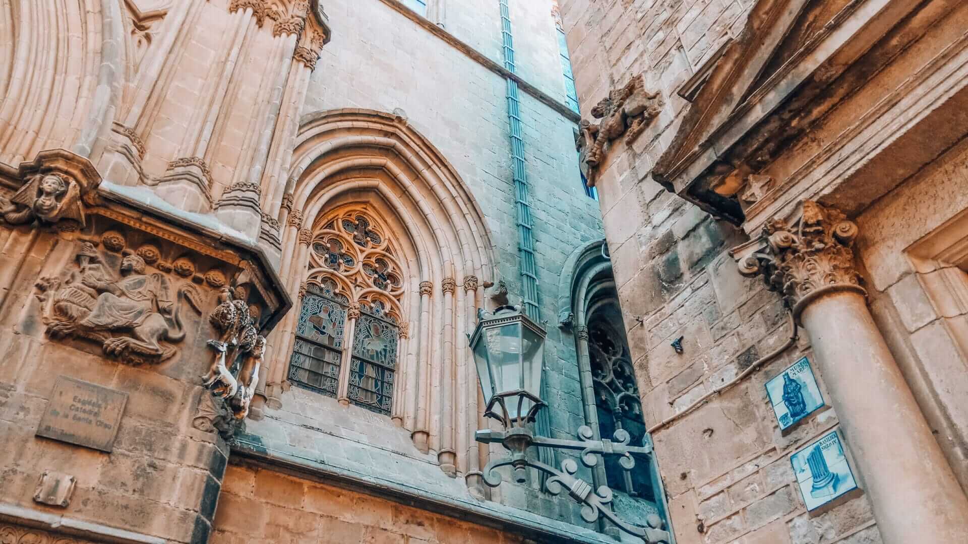 Gothic windows, gargoyles, and carvings at Plaça Sant Iu beside Barcelona Cathedral in the Gothic Quarter.